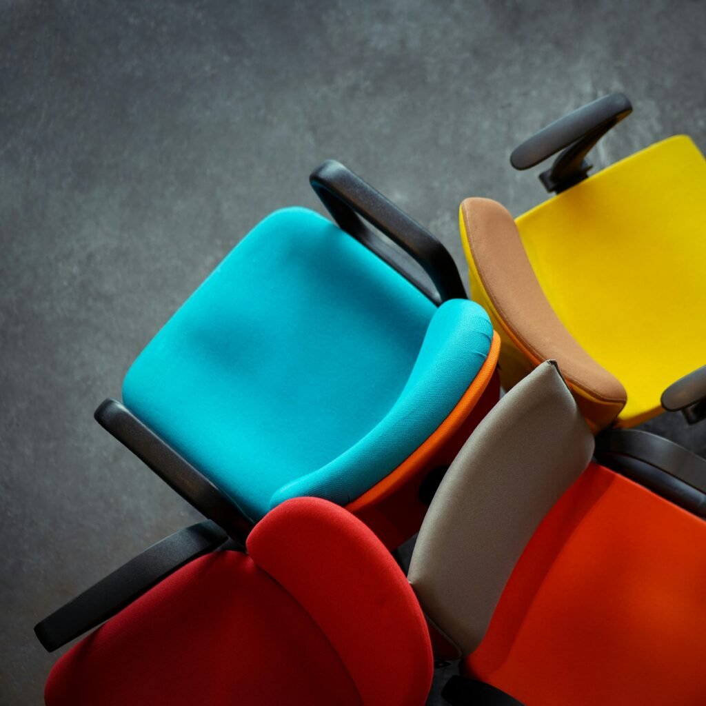A vibrant collection of multi-colored office chairs viewed from above, showcasing modern design.